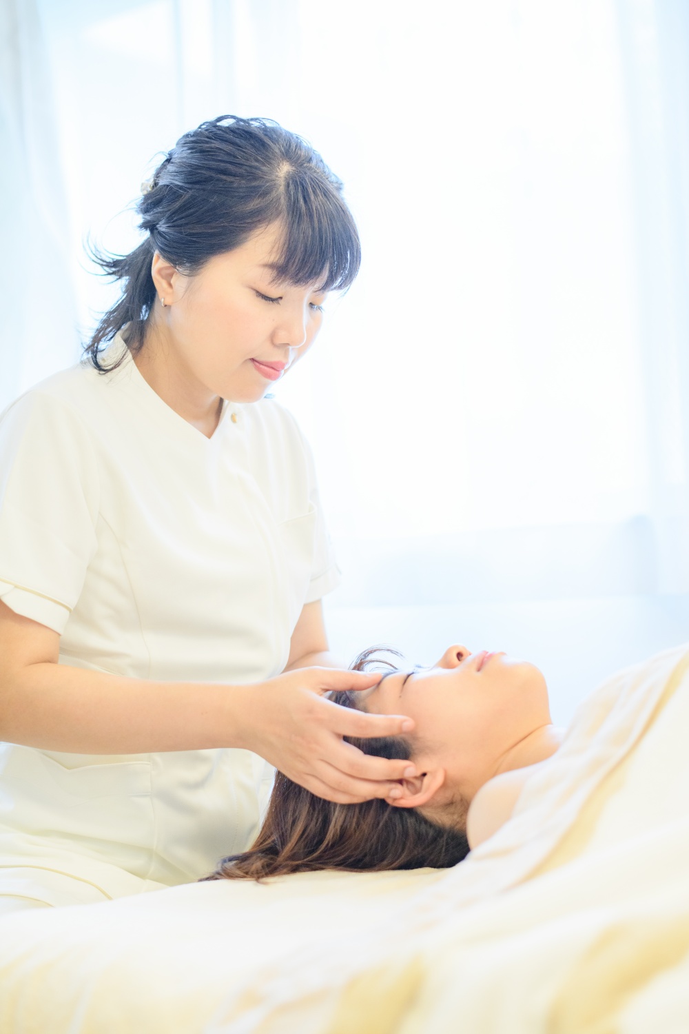 フェイシャル施術の様子。手のぬくもりでお肌を整える。